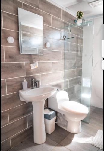 a bathroom with a white sink and a toilet at Fruta mango # 1 in Playa Guacalillo