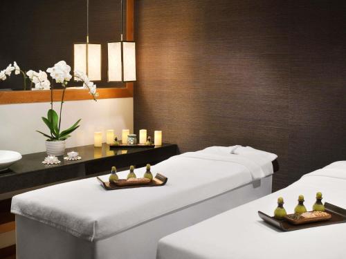 a room with two beds and a table with candles at Mövenpick Hotel Jumeirah Beach in Dubai
