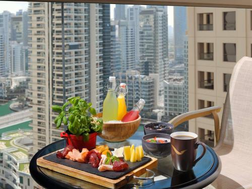 - un plateau de nourriture sur une table avec vue sur la ville dans l'établissement Mövenpick Hotel Jumeirah Beach, à Dubaï