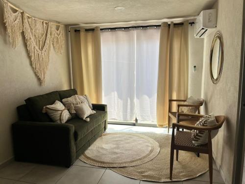 a living room with a couch and a window at Acojedor departamento en el centro de Guadalajara in Guadalajara