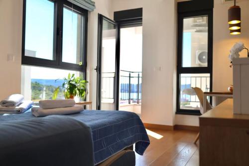 1 dormitorio con 1 cama azul y ventanas grandes en Valmere Members Luxury Sea View Apartment Tivat, en Tivat