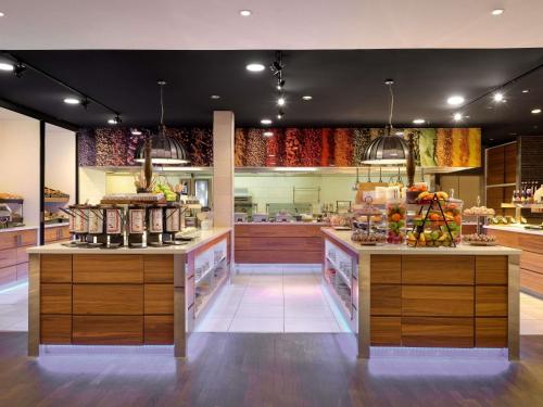 Una gran cocina con dos mostradores con comida. en Mövenpick Hotel Amsterdam City Centre, en Ámsterdam