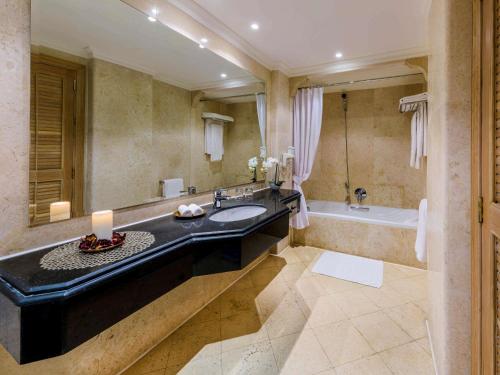 a bathroom with a large sink and a tub at Movenpick Taba Resort & Spa in Taba