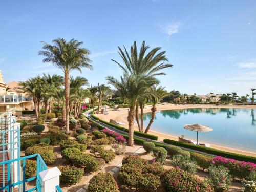 a view from the balcony of a resort with a pool and palm trees at Movenpick Resort & Spa El Gouna in Hurghada