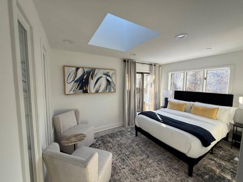 Highland LakesTop Luxe Oasis -Ski, Hike, Firepit, Spa, Golf的一间卧室配有一张床、一把椅子和天窗