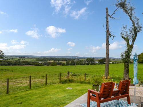 a wooden bench sitting next to a field at Trelaw - Uk41532 in Ochiltree