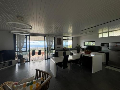 a kitchen and living room with a table and chairs at Airport Pamatai Room in Faaa