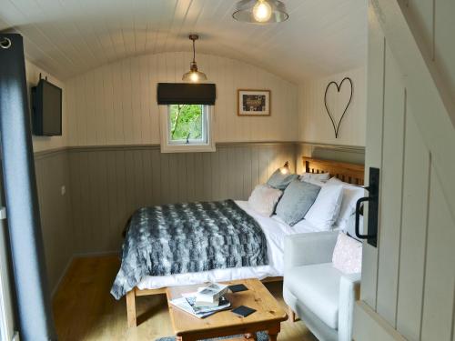 un dormitorio con una cama y un sofá en Caban Caru, en Dinas Mawddwy