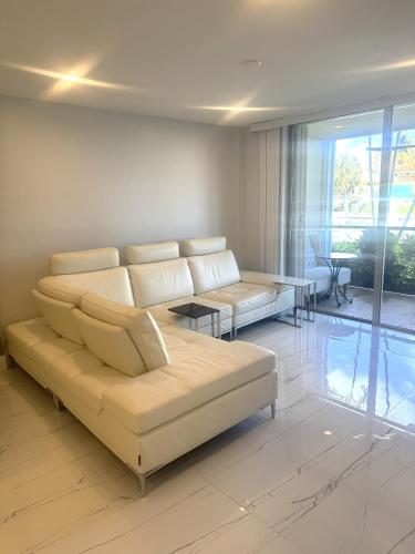 a living room with a couch and a table at Exclusive Waterfront Condo in North Palm Beach