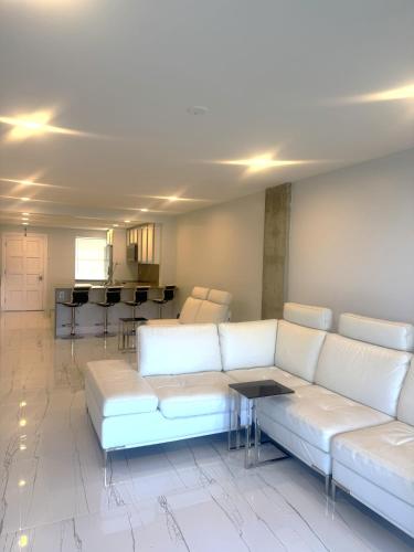 a living room with a white couch and a table at Exclusive Waterfront Condo in North Palm Beach