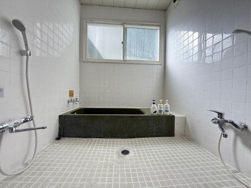 a bathroom with a bath tub and a shower at 玄関開けたらスキー場!400平米の贅沢空間で大型犬もOKシアタールーム完備 Skiin 400m2 Luxury Lodge Large Dogs OK Big Theater Room in Yonezawa