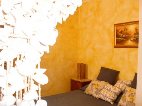ファヴィニャーナにあるFavignana Margot Houseのベッドとシャンデリアが備わる客室です。