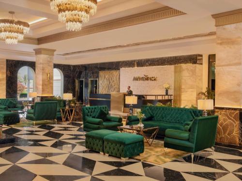 十月六日城Mövenpick Hotel Cairo - Media City的配有绿色沙发和沙龙的大堂