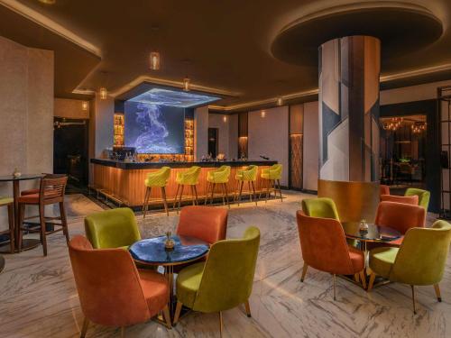 Un vestíbulo con mesas y sillas y un bar. en Mövenpick Hotel Cairo - Media City, en Seis de Octubre