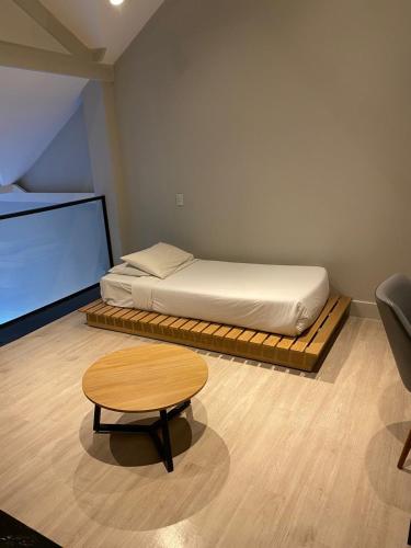 a small room with a bed and a table at Hotel Resort Carpe Diem 2Q in Campos do Jordão