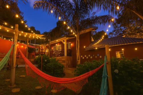 een hangmat voor een huis 's nachts bij Pousada Villa Bergamin, Monte Verde in Monte Verde