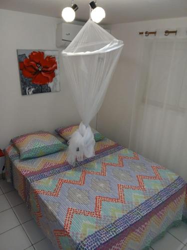a bed with a white stuffed animal on top of it at Chez Fab & Ketty in Le Moule