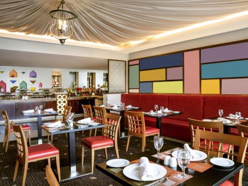 a restaurant with tables and chairs and a bar at Movenpick Hotel & Residences Hajar Tower Makkah in Makkah