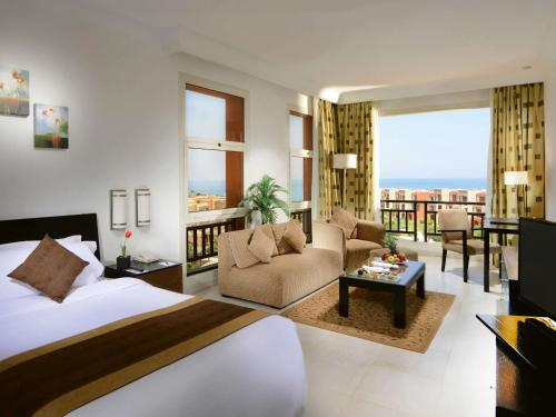 une chambre avec un lit et un salon dans l'établissement Mövenpick Resort El Sokhna, à Ain Sokhna