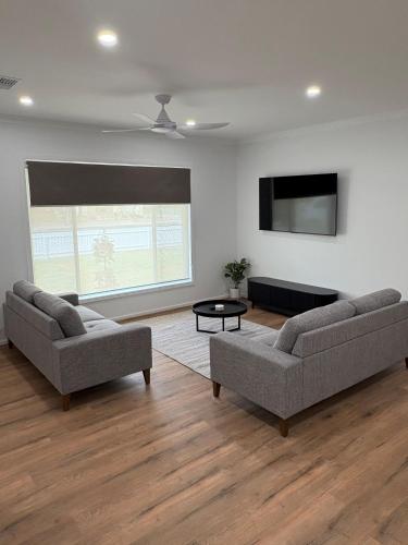 a living room with two couches and a flat screen tv at The Townhouse in Renmark
