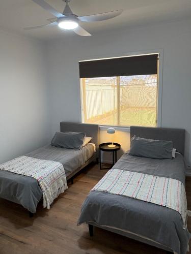 a bedroom with two beds and a ceiling fan at The Townhouse in Renmark