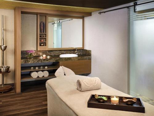 un bagno con un lavandino e un letto in una stanza di Mövenpick Hotel Karachi a Karachi