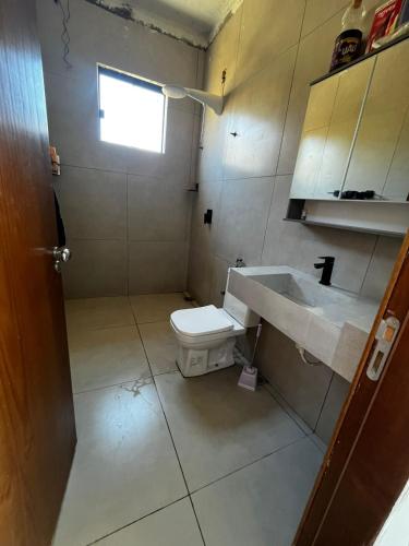 a bathroom with a toilet and a sink at Casa no Lago em Corumbá 4 in Alexânia