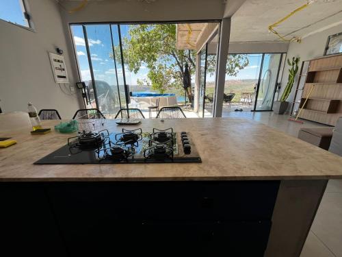 une cuisine avec une cuisinière sur un comptoir dans l'établissement Casa no Lago em Corumbá 4, à Alexânia