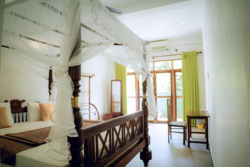 un dormitorio con una cama con dosel en Sea wind, en Mirissa