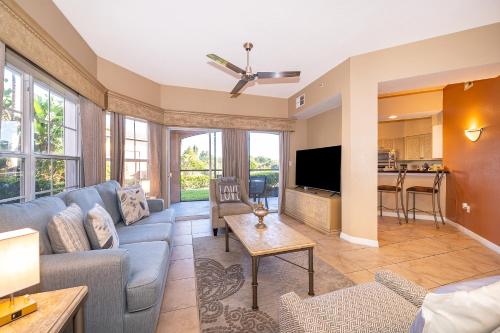 a living room with a blue couch and a kitchen at Pura Vida in Orlando