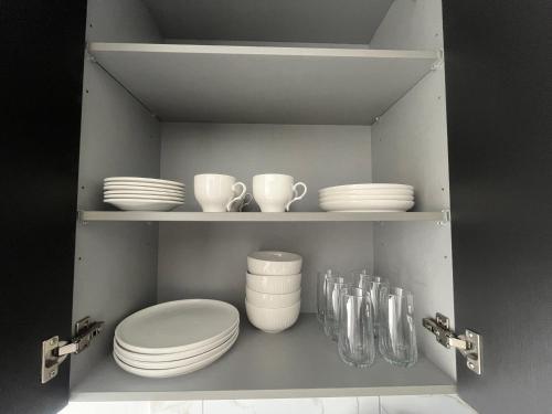 a shelf with plates and cups and dishes on it at Moderno apartamento en el centro de Obarrio in Panama City