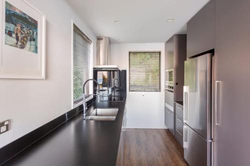 een keuken met een spoelbak en een koelkast bij The Twins in Queenstown