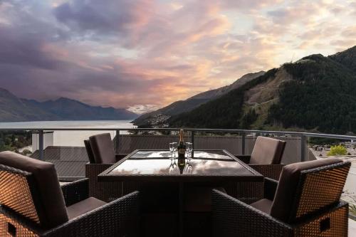 a table with chairs and a view of the water at The Queenstown Bothy in Queenstown