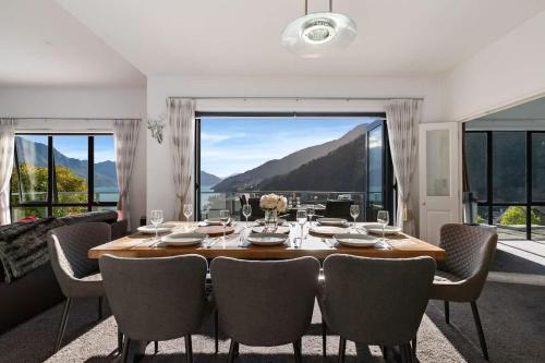 a dining room with a table and chairs and a large window at The Queenstown Bothy in Queenstown
