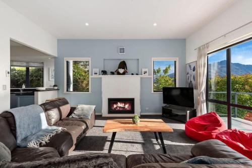 a living room with a couch and a fireplace at The Queenstown Bothy in Queenstown