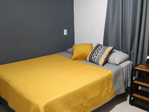 a yellow bed with two pillows on top of it at Casa Jardín Los Potreros in San Juan Teotihuacán