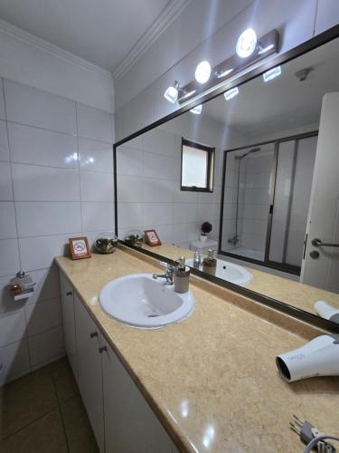 une salle de bain avec deux lavabos et un grand miroir dans l'établissement MACHALI HABITACION PRIVADA PARCKING y WIFI, à Machalí