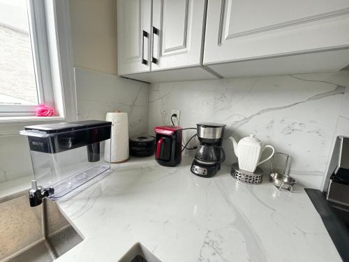 - un comptoir de cuisine avec une cafetière dans l'établissement Mississauga Guest House McDowell, à Mississauga