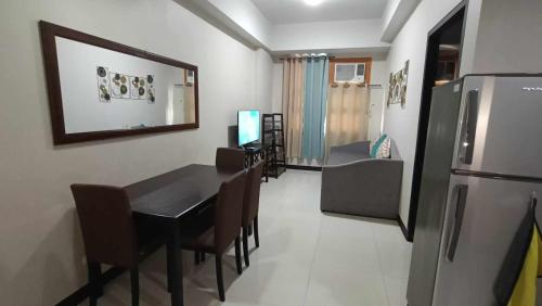 a dining room with a table and a refrigerator at Condo Unit walking distance to Manila Airport (NAIA Terminal 3) in Manila