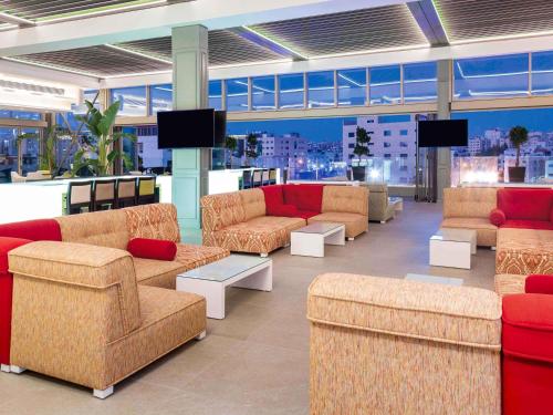 une grande pièce avec des canapés et des chaises dans un magasin dans l'établissement Mövenpick Hotel Amman, à Amman