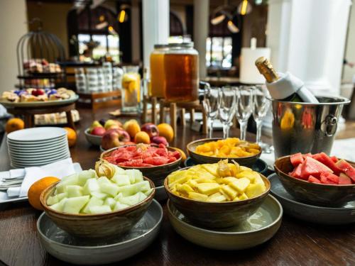 Una mesa con cuencos de diferentes frutas y verduras. en Rezydent Hotel Sopot - MGallery Collection, en Sopot