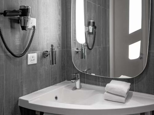a bathroom with a sink and a large mirror at ibis Jeddah City Center in Jeddah