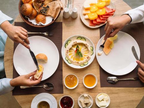 Un grupo de personas comiendo comida en una mesa. en ibis Jeddah City Center, en Yeda