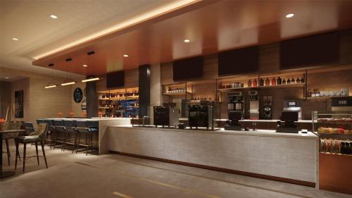 a restaurant with a bar with stools at Tempo By Hilton Manassas in Manassas