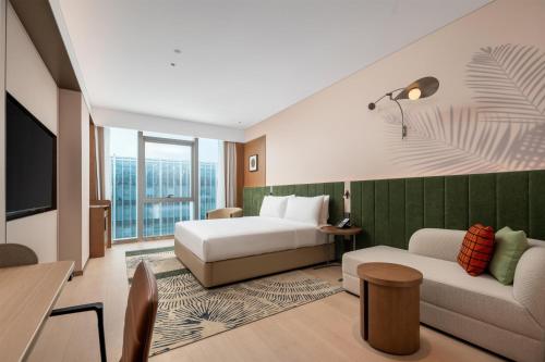 a hotel room with a bed and a couch at Hilton Garden Inn Wuhu Economic Tech Zone in Wuhu