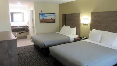 a hotel room with two beds and a bathroom at Quality Inn & Suites in Hesperia