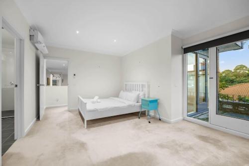 a white living room with a couch and a table at Stylish 4BR Home in the Centro of Glen Waverley in Black Flat