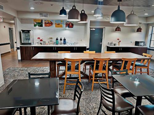 uma sala de jantar com uma grande mesa de madeira e cadeiras em Quality Inn Brewerton - Syracuse Oneida Lake Area em Brewerton