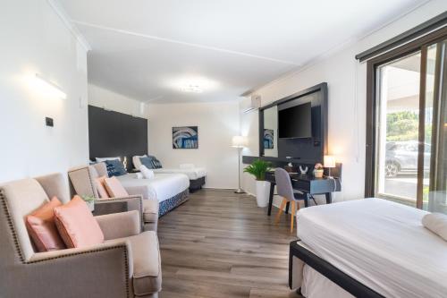 a hotel room with two beds and a flat screen tv at Motel 10 in Bankstown