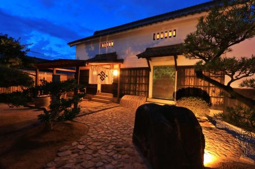 a house at night with a stone pathway in front of it at 蔵宿 みやびや in Utazu
